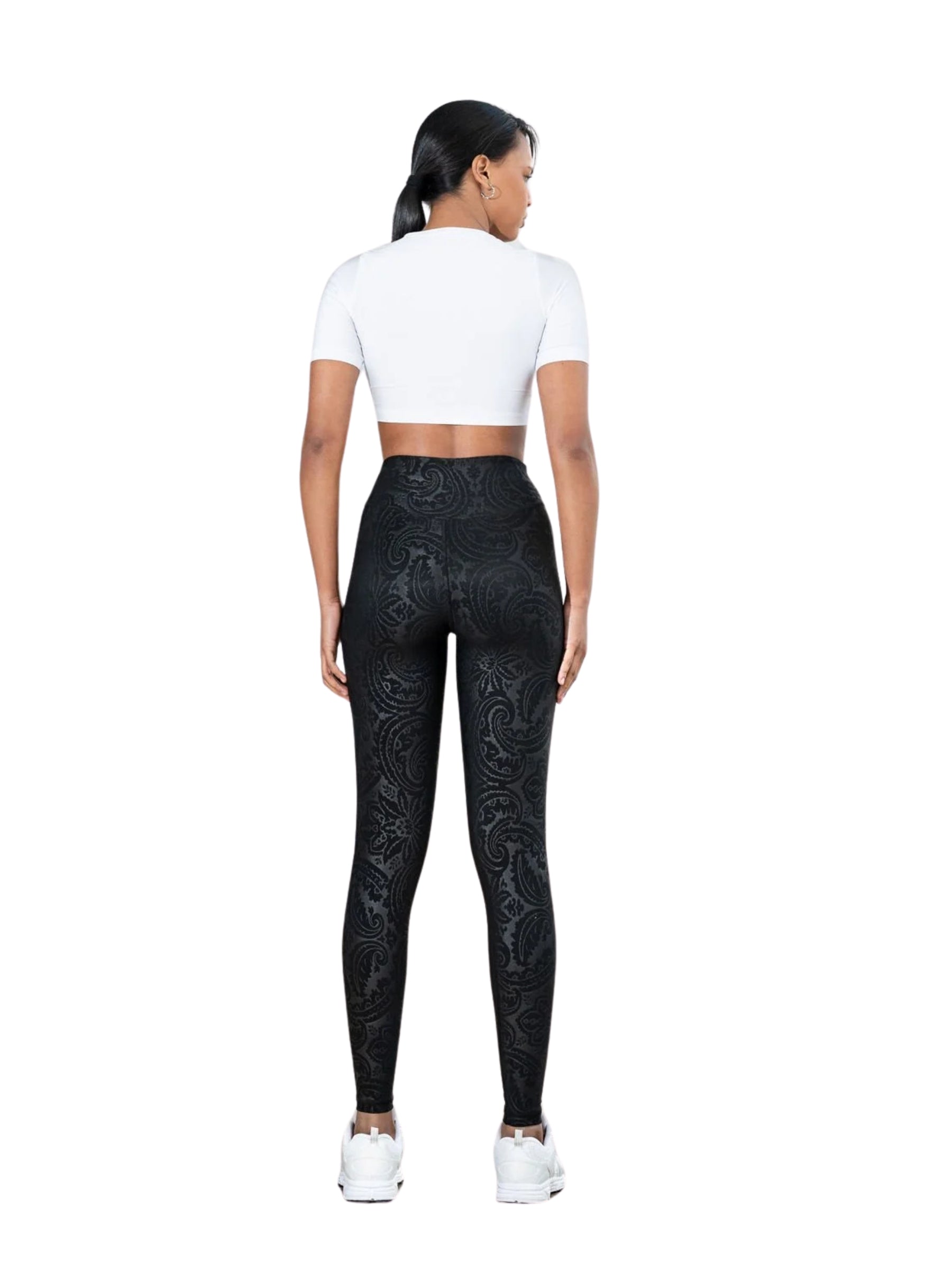 Frau in Lisminas 467 Bilboa-Leggings in Lederoptik, die mit dem Rücken zur Kamera steht.